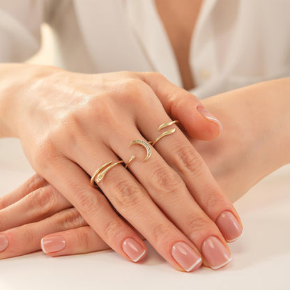 A close-up image of a person's hands wearing multiple rings on their fingers.
