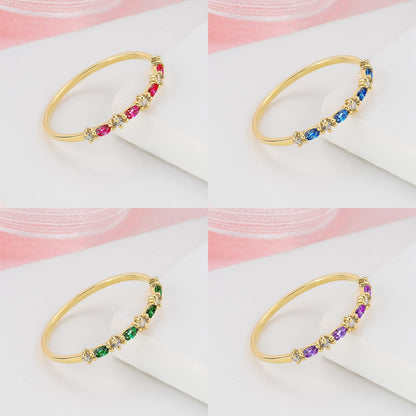 The image is a collage of four photos showing different gold rings with gemstones. The rings are arranged in a square grid pattern, with each ring displaying a unique combination of gemstones.