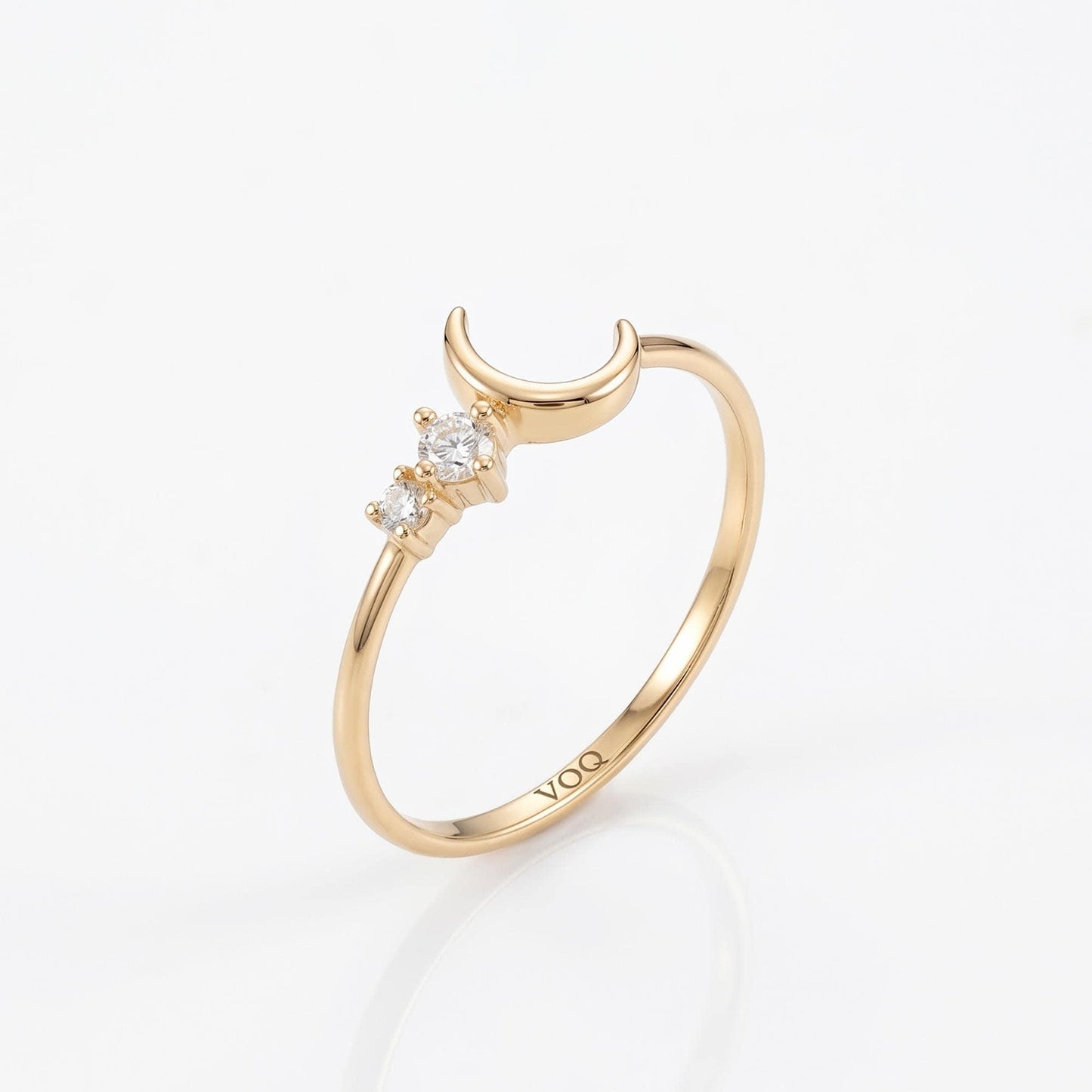 A gold ring with a crescent moon design and three small diamonds.
