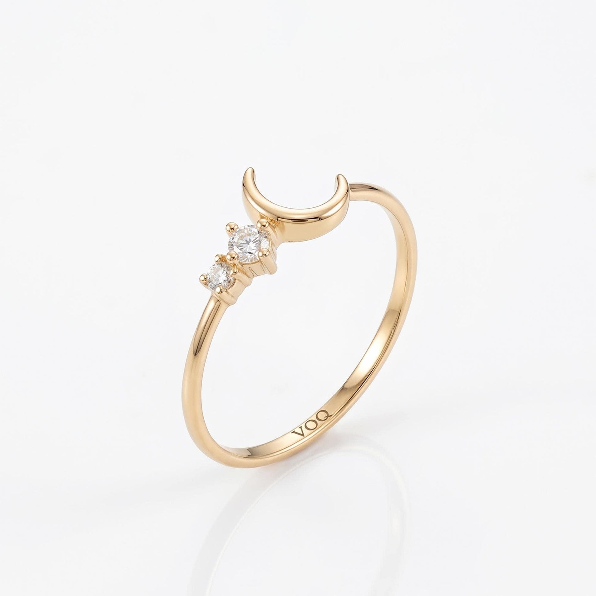 A gold ring with a crescent moon design and three small diamonds.