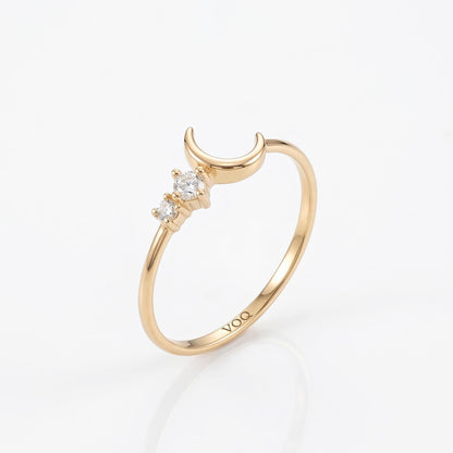 A gold ring with a crescent moon design and three small diamonds.