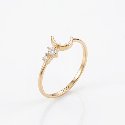 A gold ring with a crescent moon design and three small diamonds.