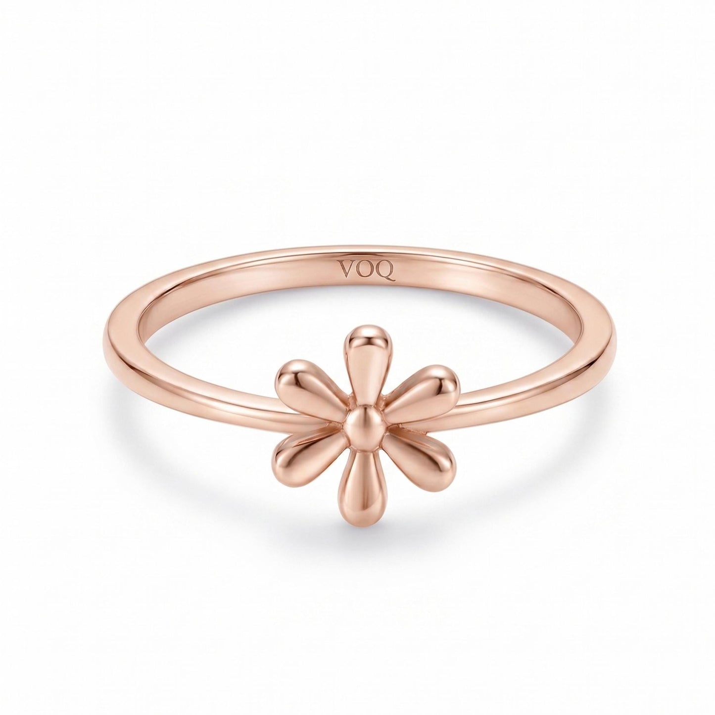 A rose gold ring with a flower design on the band.