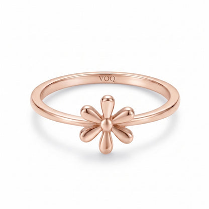 A rose gold ring with a flower design on the band.