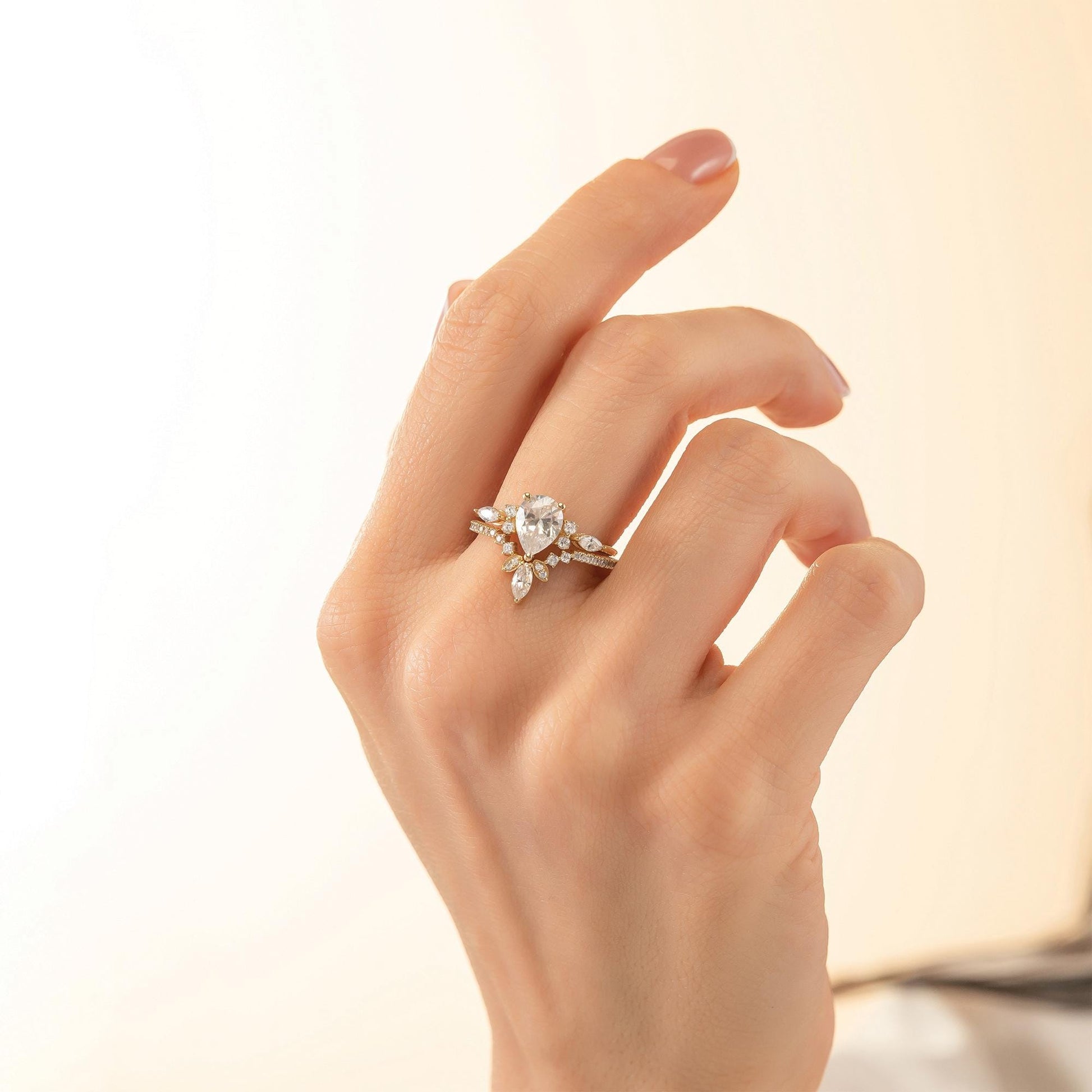 A close-up of a hand wearing a diamond engagement ring with a large central diamond surrounded by smaller diamonds.