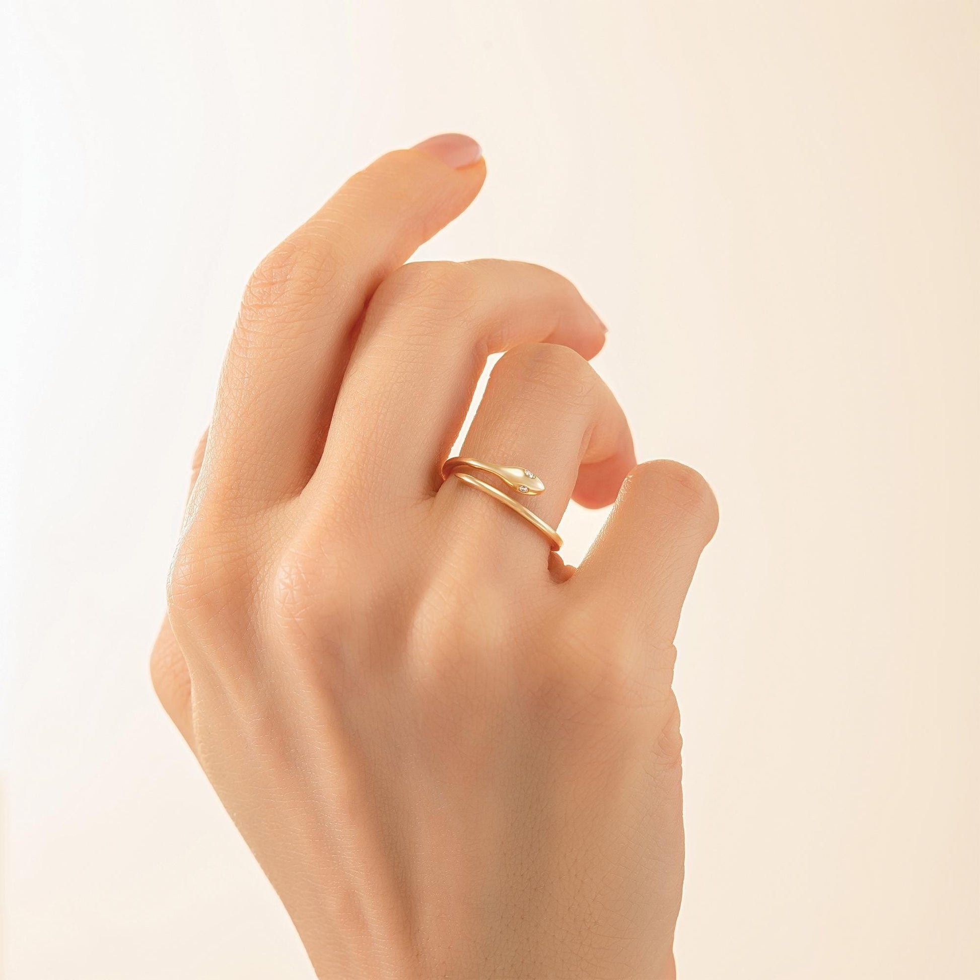 A close-up of a hand wearing a gold ring on the ring finger.