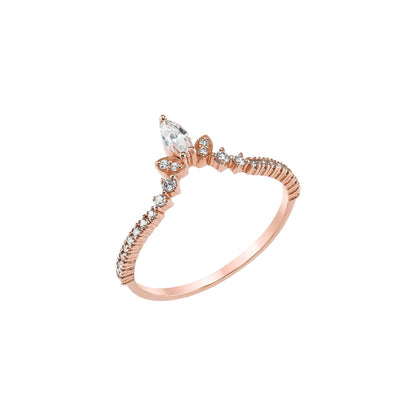 A rose gold ring with a large central diamond and smaller diamonds arranged in a decorative pattern around the band.