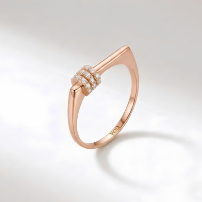 A rose gold ring with a unique design and a small cluster of diamonds set in the center.