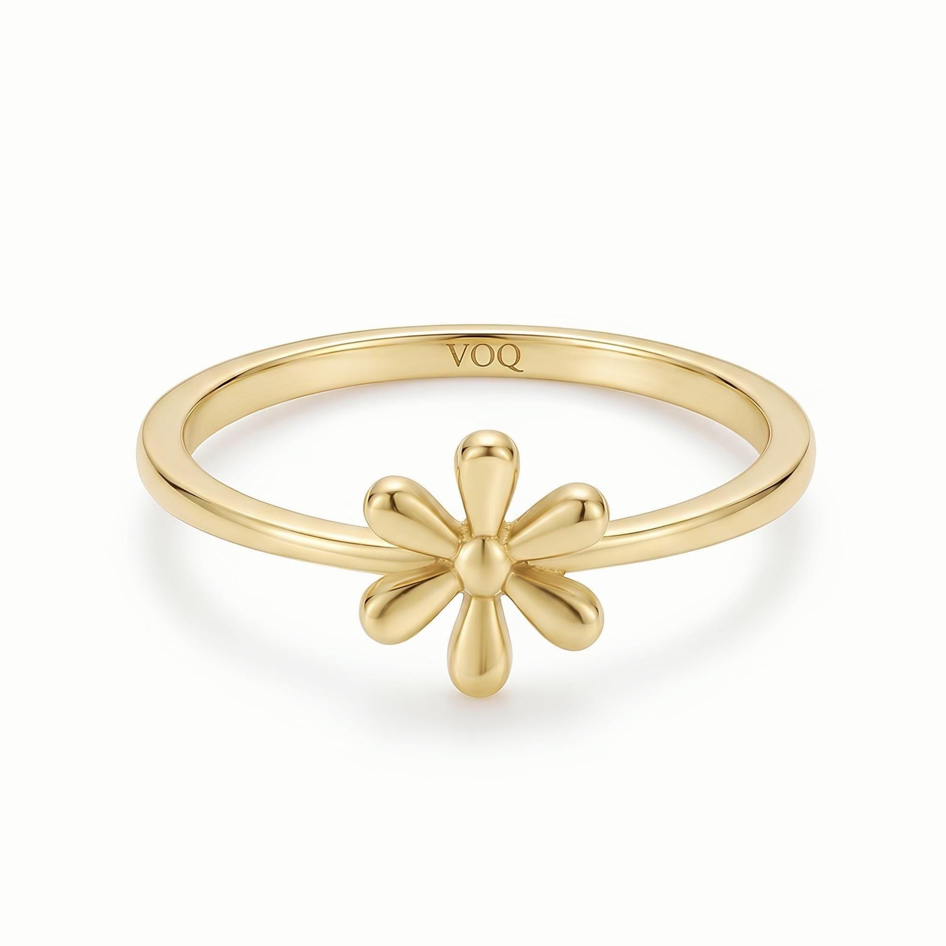 A gold ring with a flower design on the band.