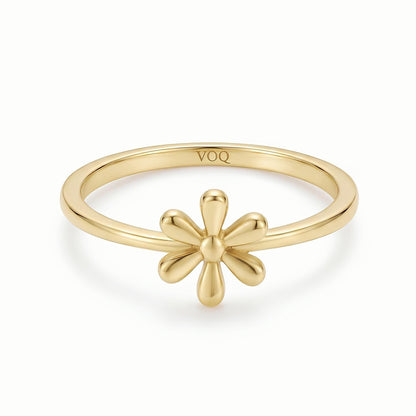 A gold ring with a flower design on the band.