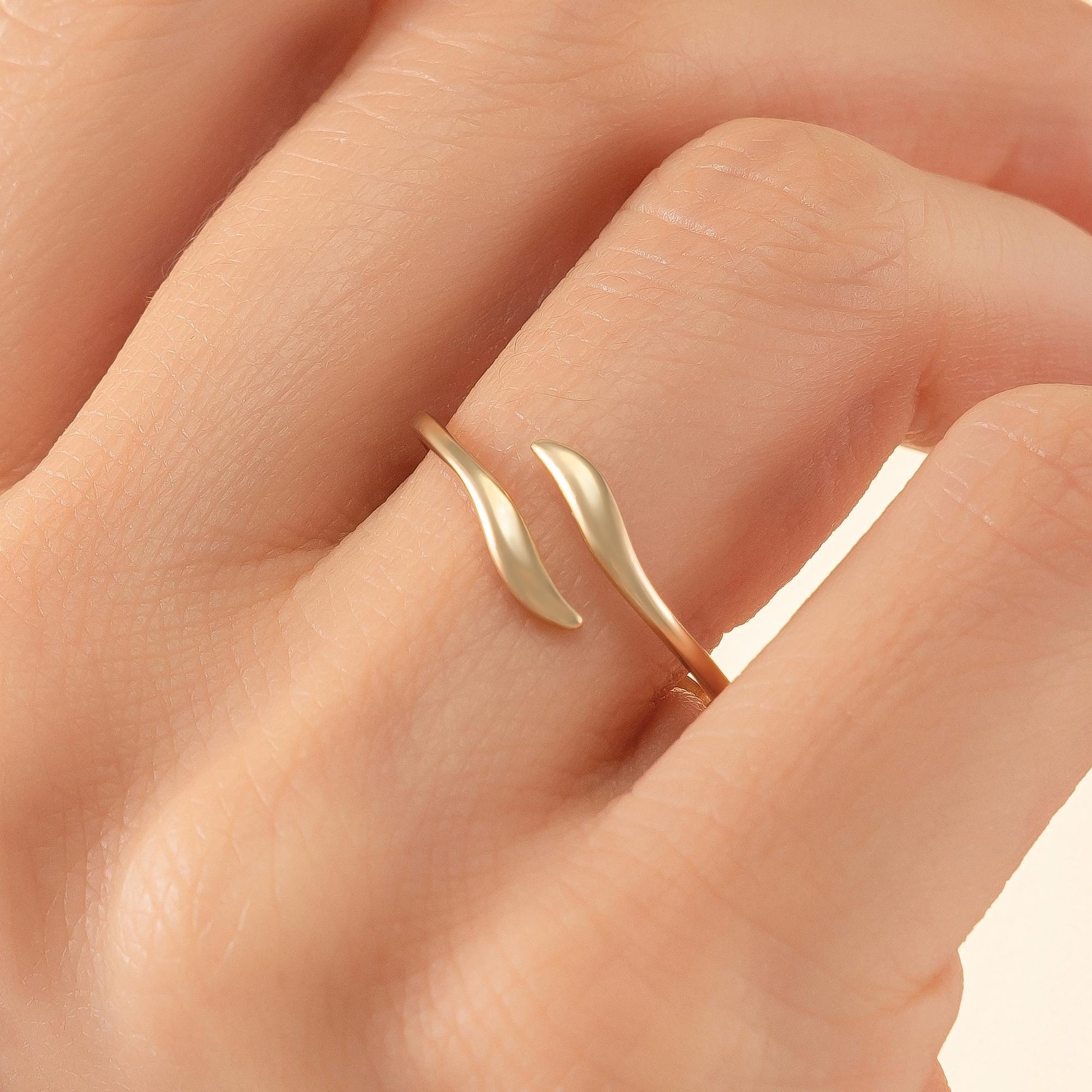A close-up image of a gold ring on a person's finger.