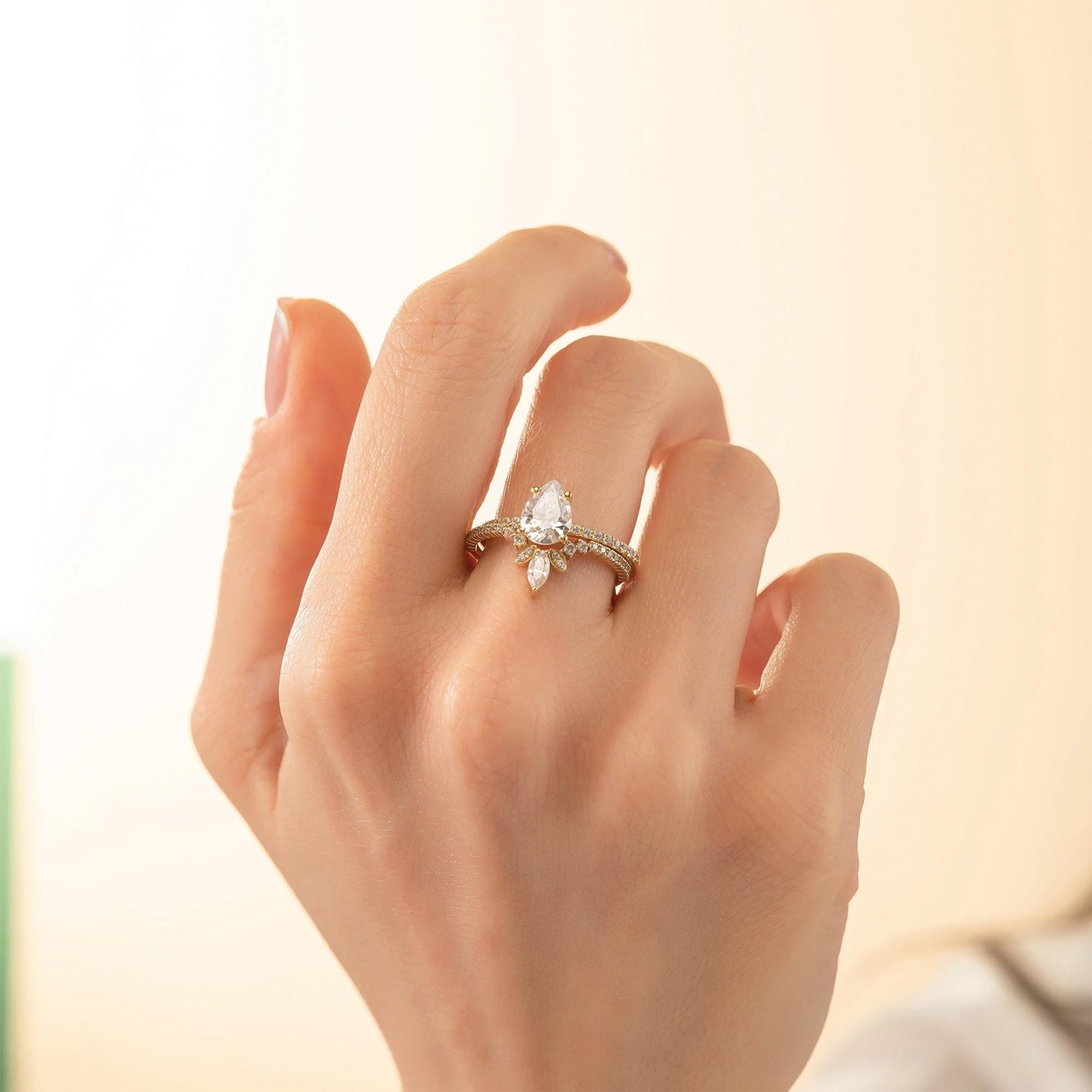 A close-up of a person's hand wearing a gold ring with a large diamond.