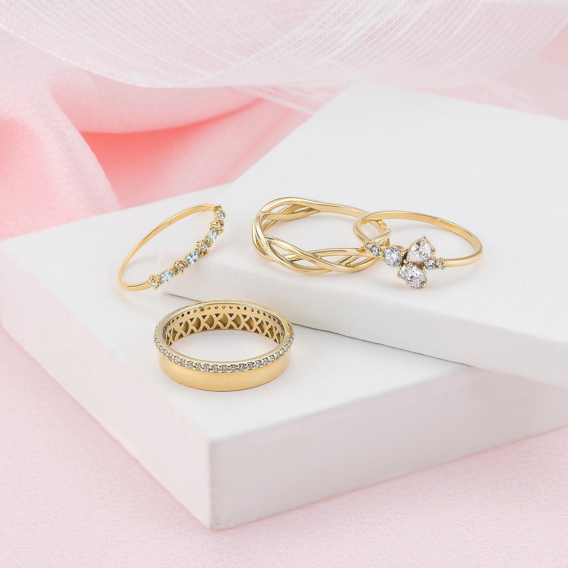 a collection of gold rings and jewelry, including a ring with a large diamond and several other rings with various designs and gemstones.