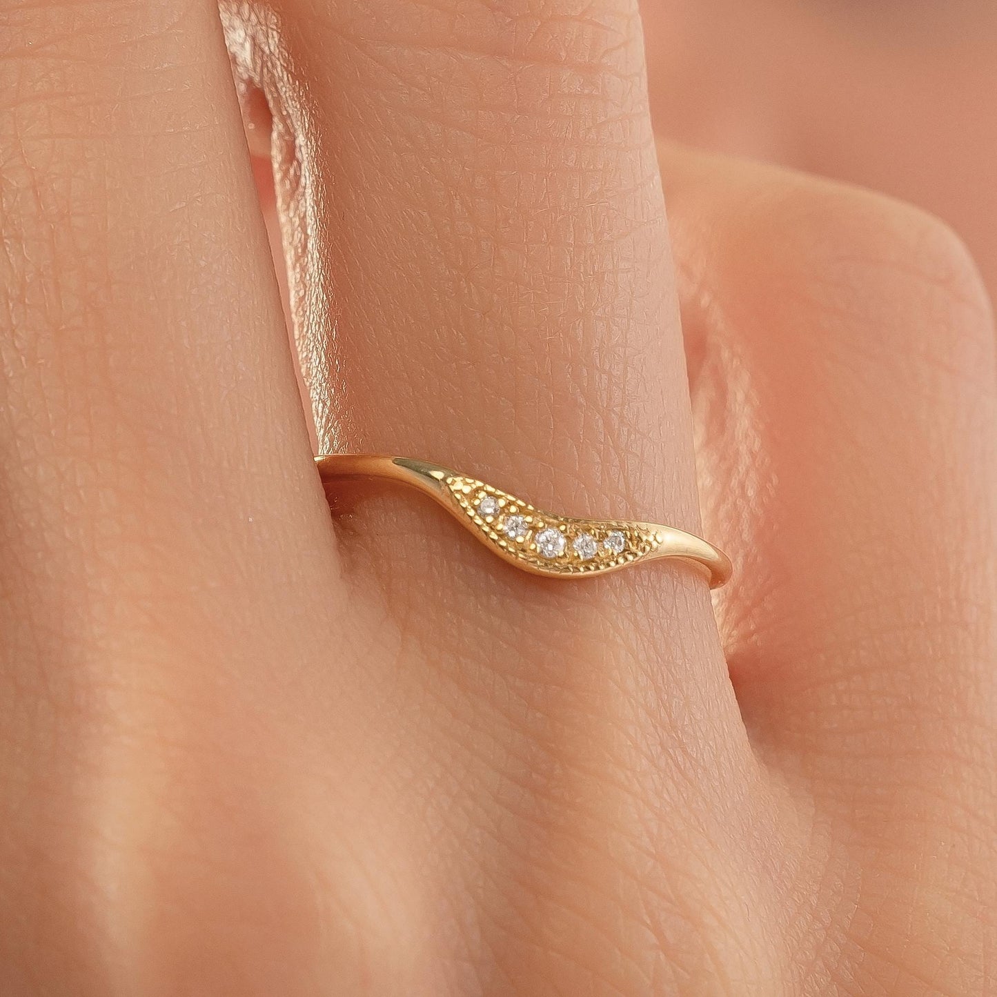 A close-up of a gold ring with a diamond accent on the band.