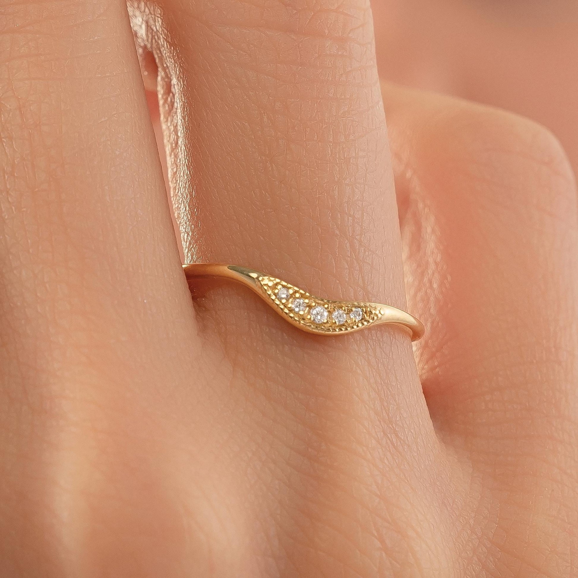 A close-up of a gold ring with a diamond accent on the band.