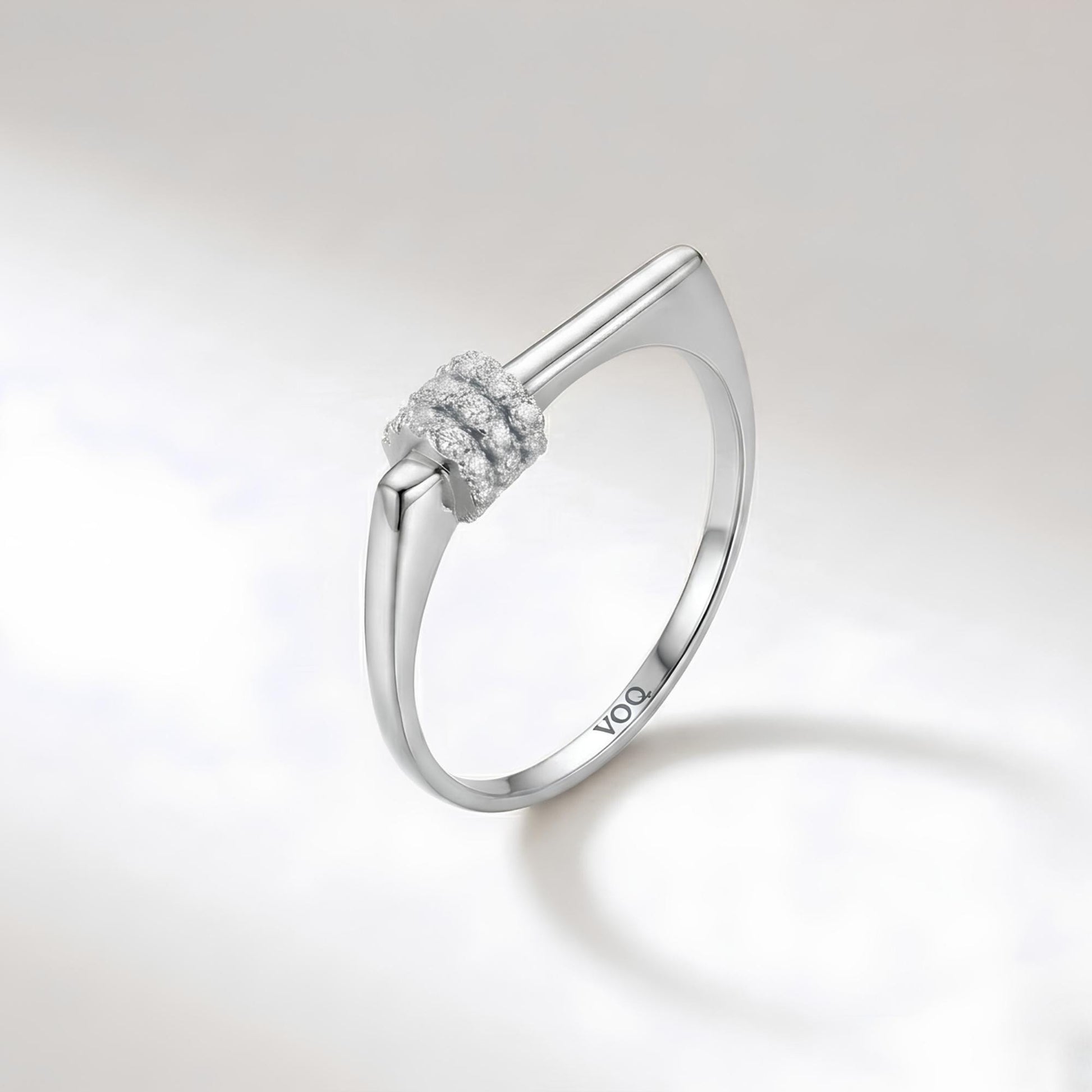 A silver ring with a diamond cluster on the band.