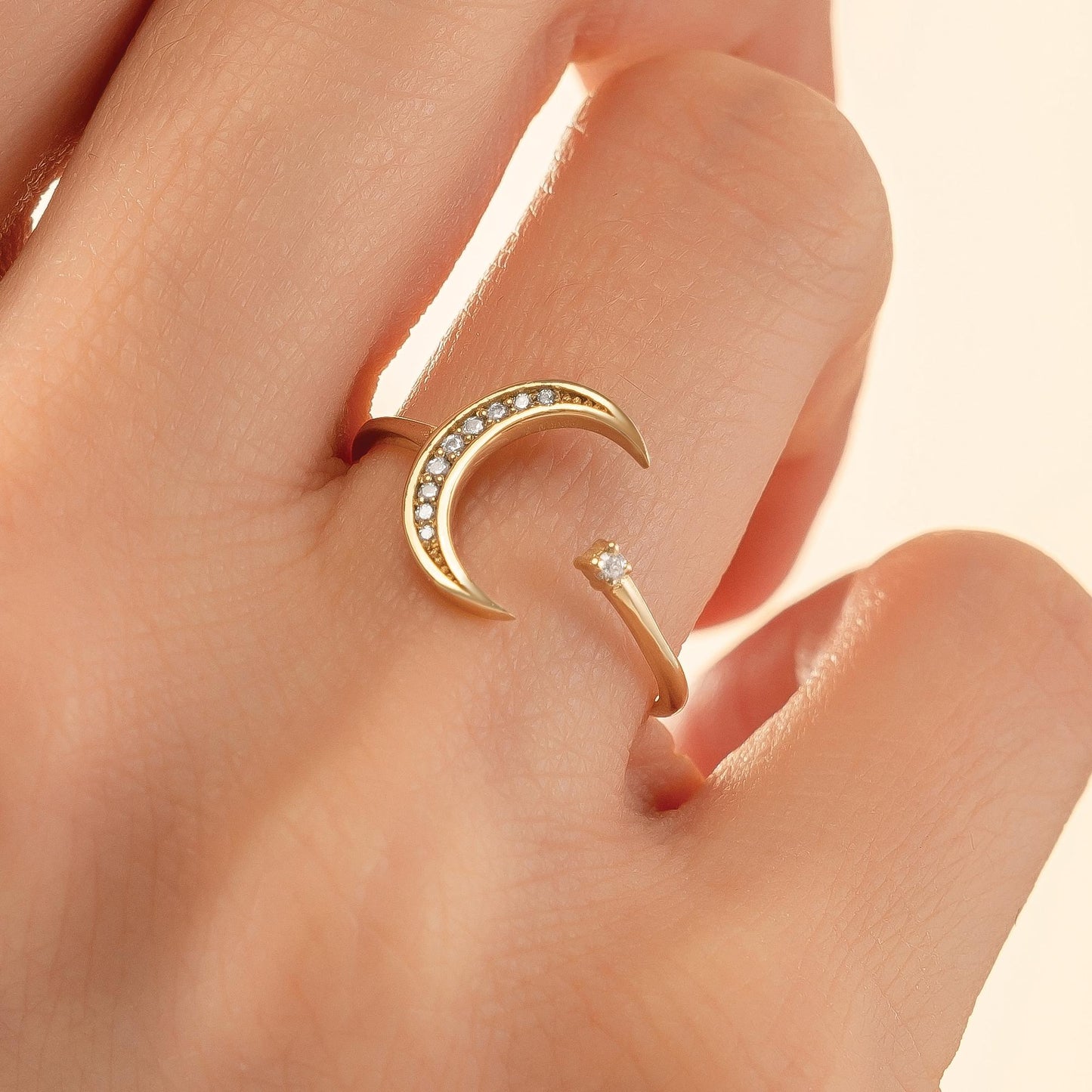 A gold ring with a crescent moon design and small diamonds set in it.