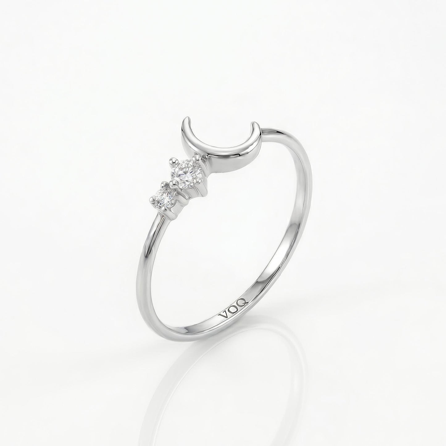 A silver ring with a crescent moon and three small diamonds set in the center.