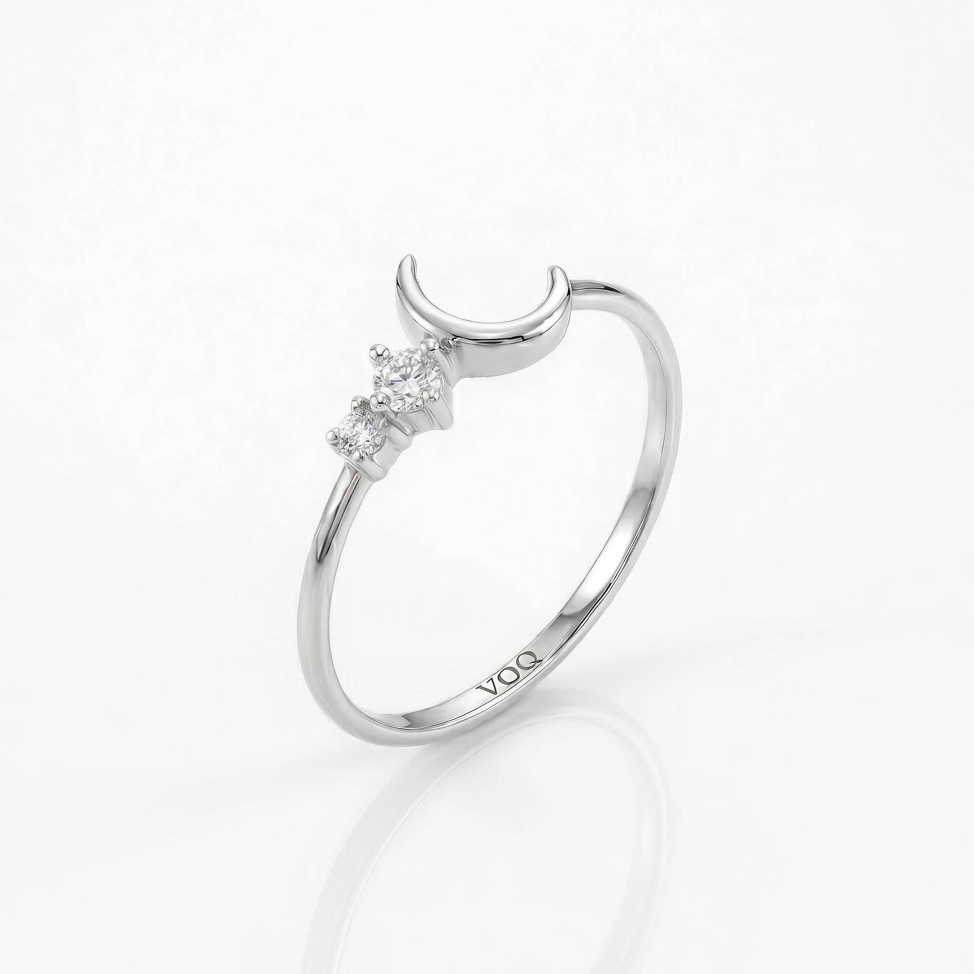A silver ring with a crescent moon and three small diamonds set in the center.