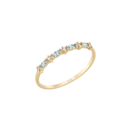 A gold ring with a row of blue gemstones on the band.