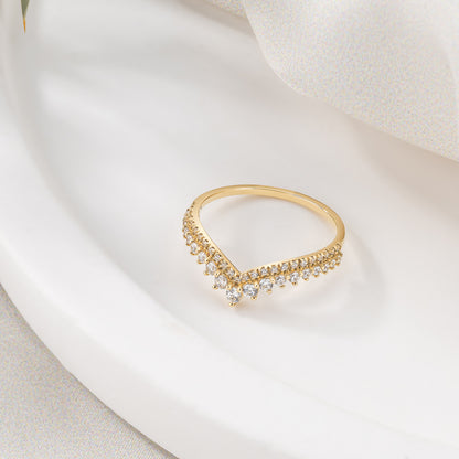 A gold ring with a diamond-encrusted band is displayed on a white surface.