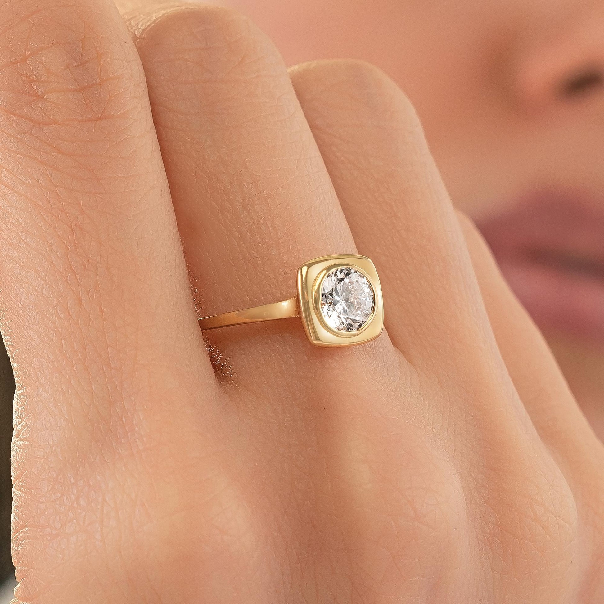 A close-up of a gold ring with a large, clear gemstone set in the center.