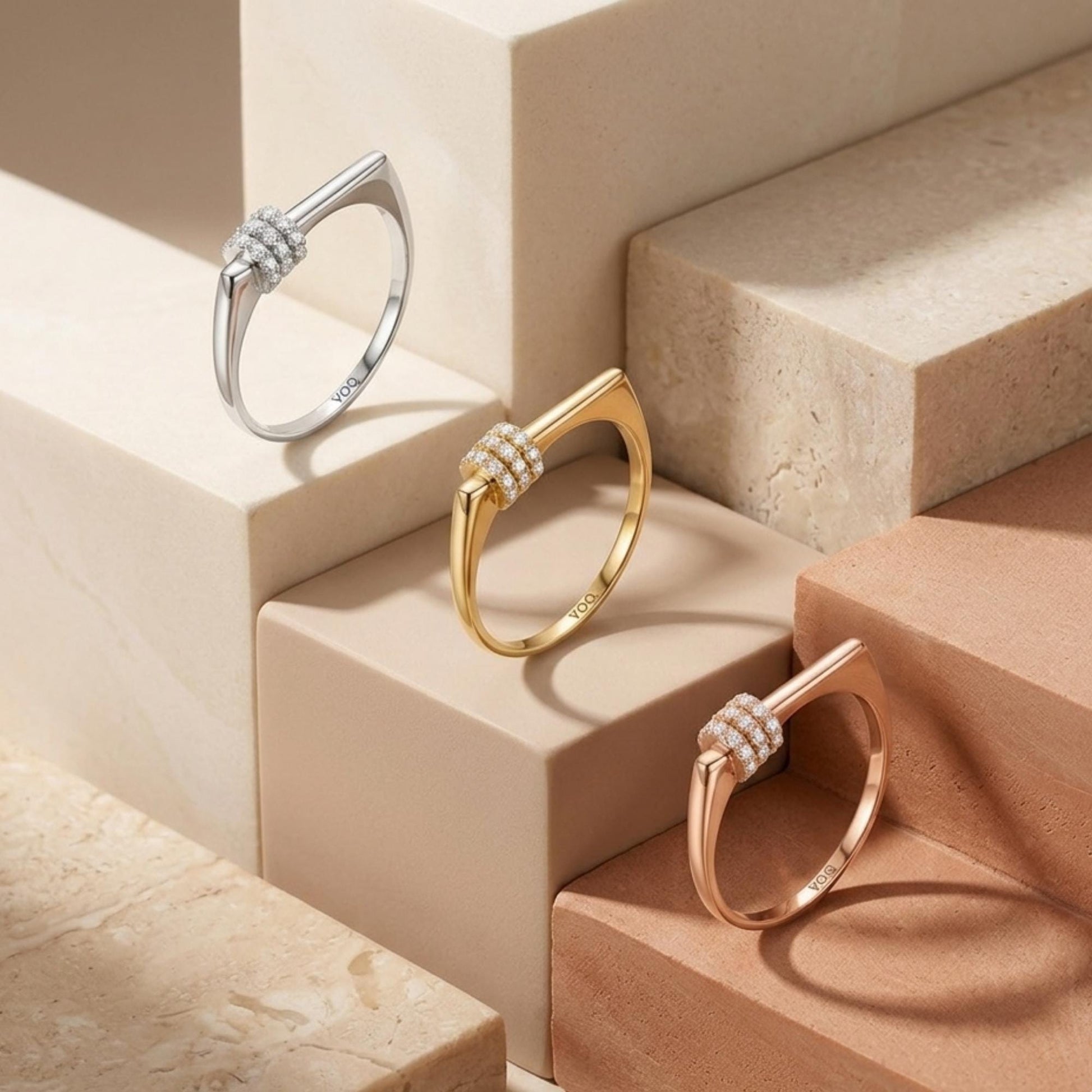 Three rings are displayed on a marble surface, each with a unique design and color.