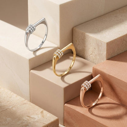 Three rings are displayed on a marble surface, each with a unique design and color.
