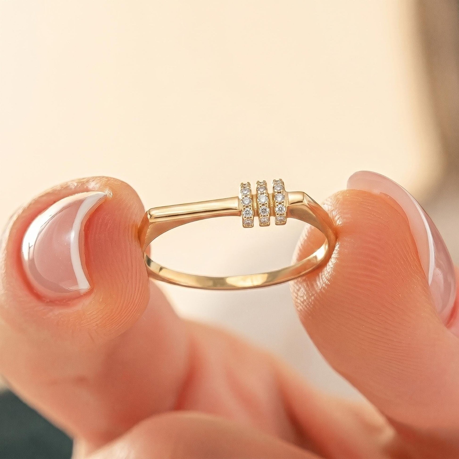 A close-up image of a person's hand holding a gold ring with a small diamond accent.