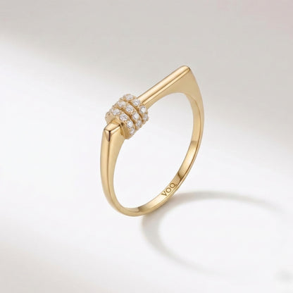 A gold ring with a diamond-encrusted band and a unique, angular design.