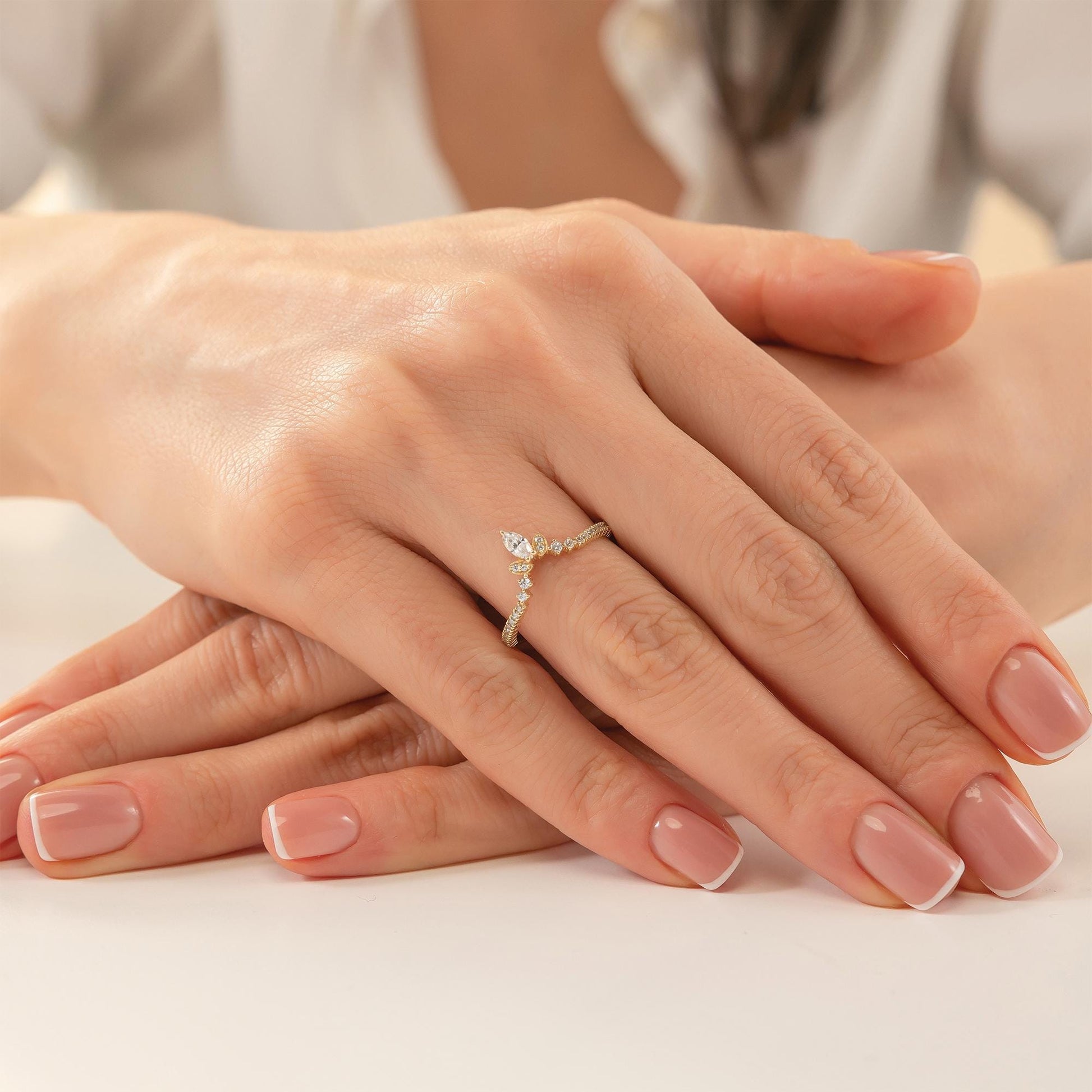 A close-up image of a person's hands with a gold ring on the ring finger.